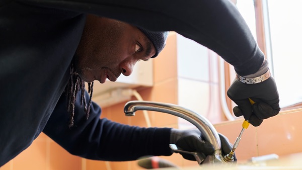 Man fixing a sink with screwdriver